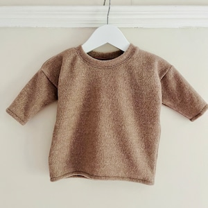 Op de afbeelding: Een bruine longsleeve trui met een ronde hals.
