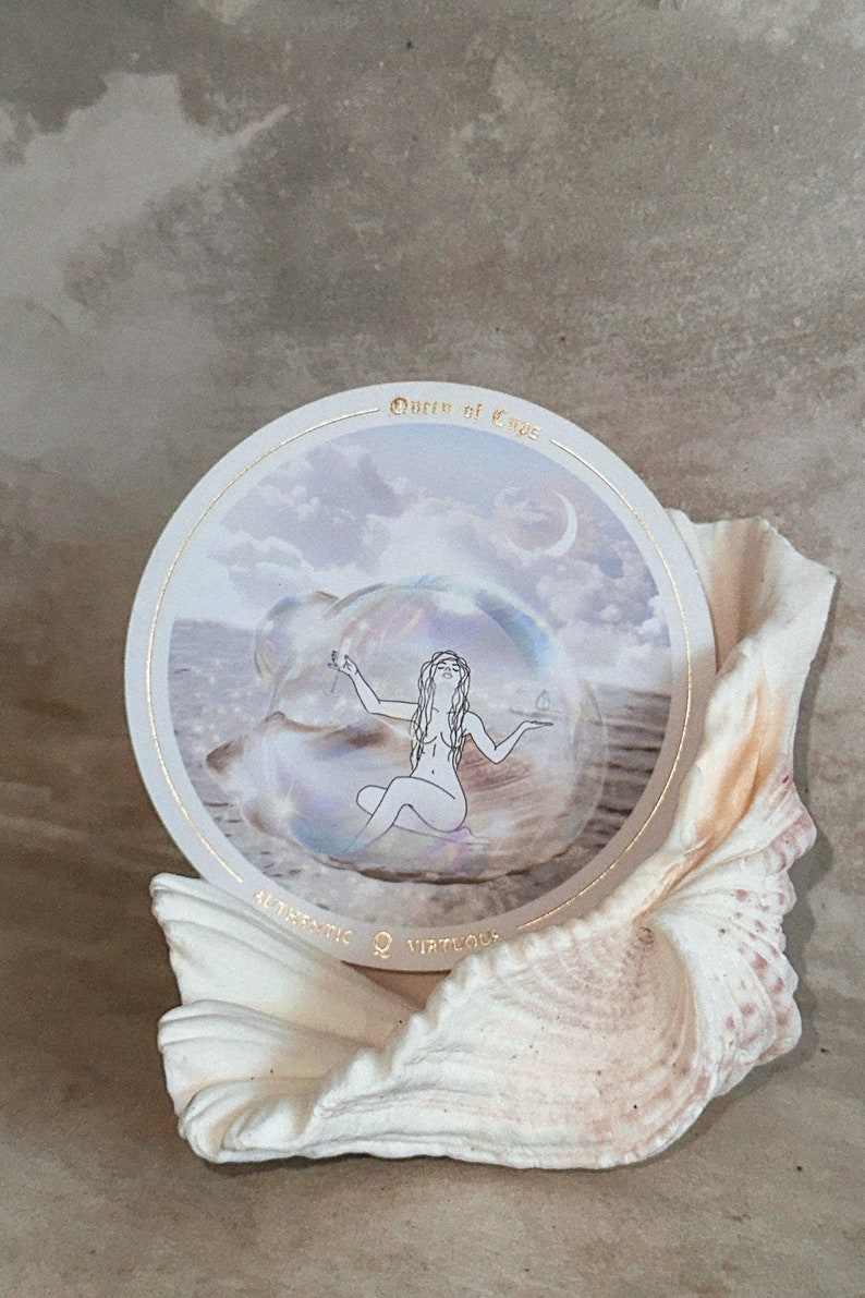 Accurate AF Tarot, tarot cards, circle tarot deck, divine feminine tarot, pink gold tarot, seashell with a tarot card the queen of cups, ocean themed tarot deck