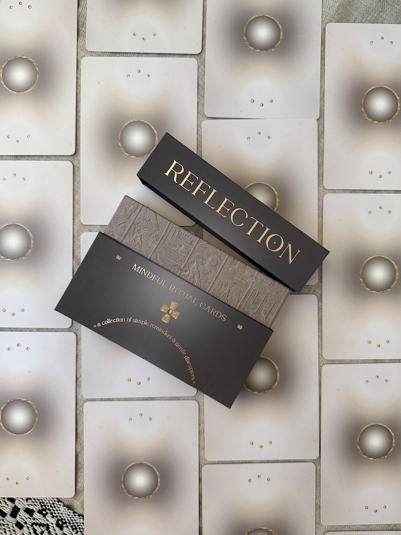 a black and gold mindful ritual card deck is laid out symmetrically with the backs of the cards showing
