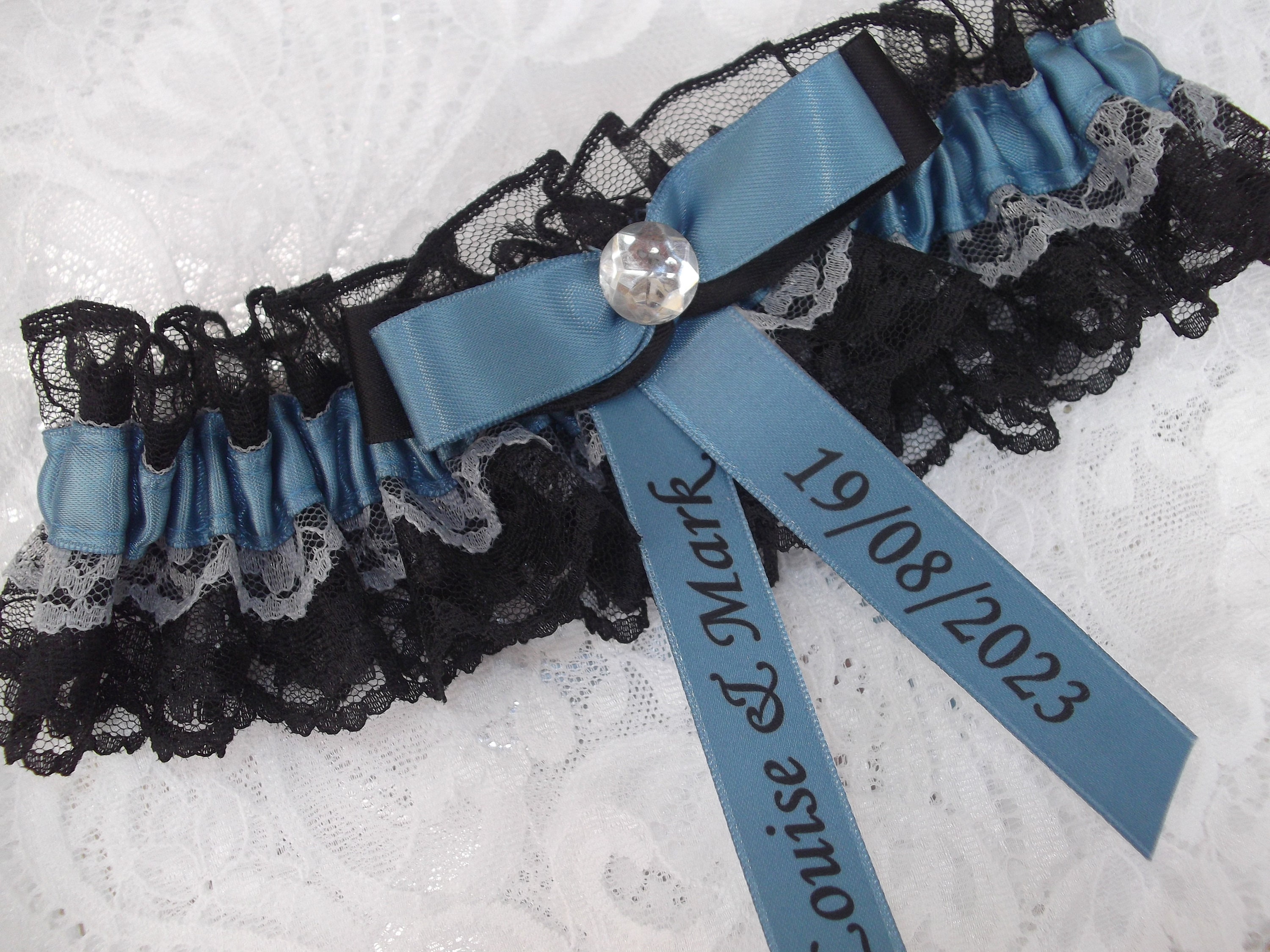 Dusky blue satin and black and silver lace design wedding garter with diamante centre