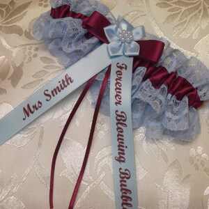May include: A blue and burgundy garter with a blue satin ribbon that says "Forever Blowing Bubbles" and another blue satin ribbon that says "Mrs. Smith".