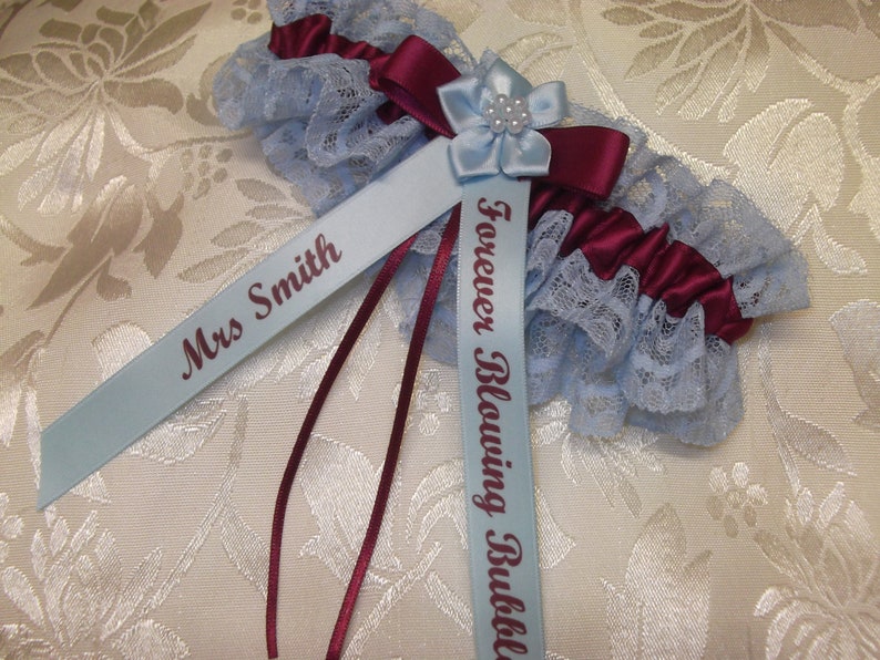 May include: A blue and burgundy garter with a blue satin ribbon that says "Forever Blowing Bubbles" and another blue satin ribbon that says "Mrs. Smith".