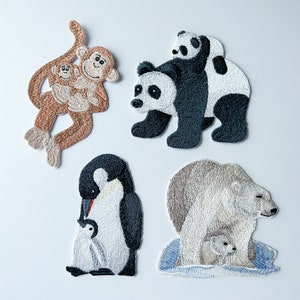 May include: Five embroidered iron-on patches featuring different animals. The patches include a brown monkey with a baby monkey, a black and white panda with a baby panda, a black and white penguin with a baby penguin, and a white polar bear with a baby polar bear.