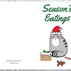 May include: A gray cat wearing a red Santa hat sits next to a gingerbread man and a decorated cake. The text "Season's Eatings" is written in green above the cat.