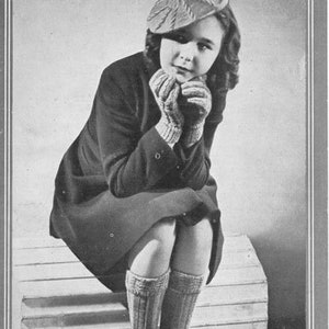 Peut inclure: Une photo en noir et blanc d'une jeune fille portant un béret, des gants et des chaussettes tricotés. La fille est assise sur une marche et regarde vers le bas. L'image provient d'une brochure de modèles de tricot vintage. Le texte sur la brochure indique "BESTWAY BERET, GLOVES AND SOCKS LEAFLET 1106 3d 8-10 Years 4 oz. of 3-ply".