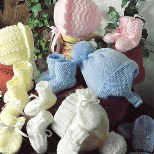 May include: A set of knitted baby booties, hats, and mittens in pink, blue, and white. The booties have a simple design and are made with a soft yarn. The hats are also simple in design and have a pom-pom on top. The mittens are a bit more elaborate and have a lace pattern.