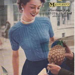 May include: A woman wearing a blue knitted jumper with a cable knit pattern. The jumper is a 3-ply Heritage yarn and is available in sizes 32-33, 35-36, and 37-38. The image also includes a pineapple and a label for "Marriner's Knitting Wools" with the number 163.