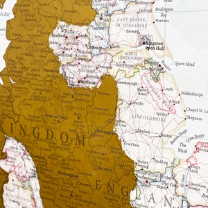 May include: A vintage-style map of England with county borders highlighted in gold. The map shows major cities, towns, and rivers. The map is printed on a cream-colored background.