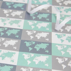 May include: A sheet of wrapping paper with a repeating pattern of world maps in shades of grey, white, and light blue.