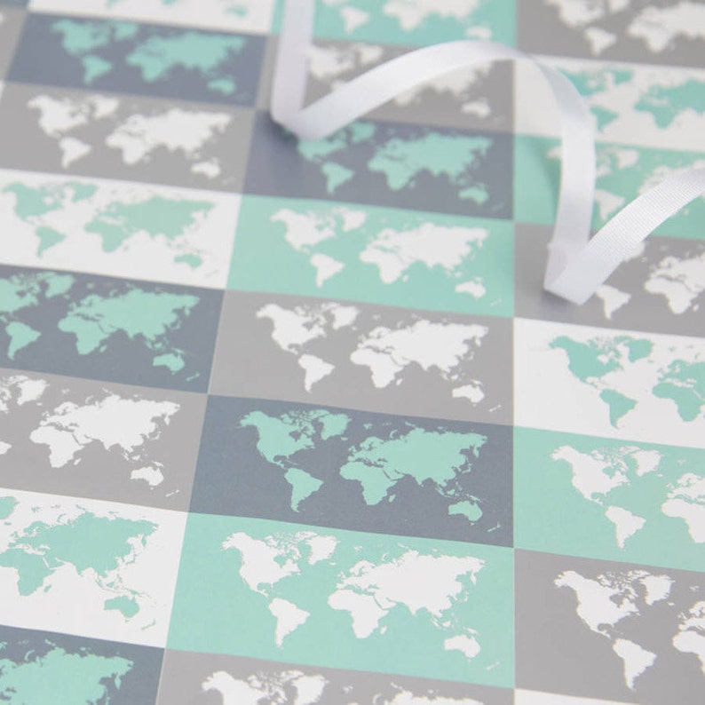 May include: A sheet of wrapping paper with a repeating pattern of world maps in shades of grey, white, and light blue.
