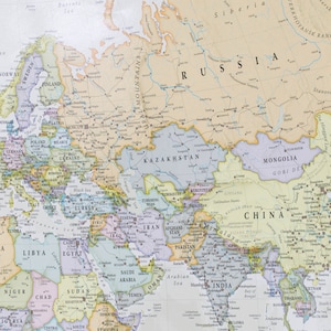 May include: A detailed map of Eurasia, showing the countries and major cities of Europe and Asia. The map is printed on a light beige background with colored borders for each country. The map includes the Ural Mountains, the Caspian Sea, the Black Sea, the Mediterranean Sea, the Arabian Sea, and the Bay of Bengal.
