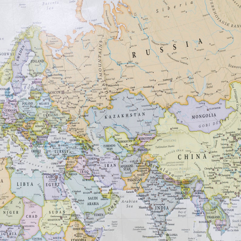 May include: A detailed map of Eurasia, showing the countries and major cities of Europe and Asia. The map is printed on a light beige background with colored borders for each country. The map includes the Ural Mountains, the Caspian Sea, the Black Sea, the Mediterranean Sea, the Arabian Sea, and the Bay of Bengal.