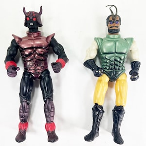May include: Two action figures. The left figure has a black body, metallic maroon chest armor, a horned helmet with red eyes, and red wrist and ankle cuffs. The right figure has a green chest piece, yellow legs, black boots, and a dark headpiece.