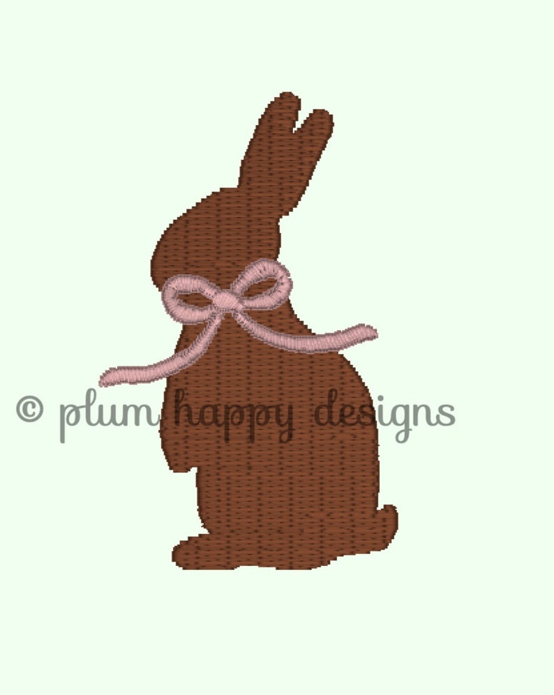 May include: A brown chocolate bunny with a pink bow. The bunny is standing on a white background.
