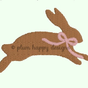 May include: A brown bunny rabbit with a pink ribbon around its neck. The bunny is jumping in the air.
