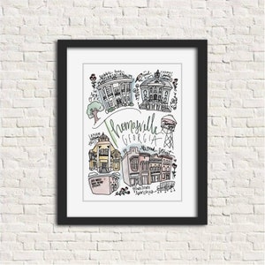 May include: A framed art print featuring a hand-drawn illustration of Thomasville, Georgia. The artwork includes sketches of local landmarks, the city name, and street names, all in a whimsical style. The print is in a black frame.