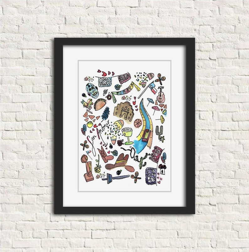 May include: A framed art print featuring a colorful watercolor illustration of San Antonio, Texas. The artwork includes iconic symbols such as the Alamo, cowboy boots, a guitar, and the San Antonio River Walk. The print is set against a white background.