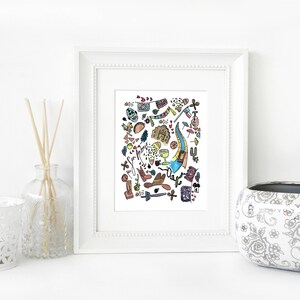 May include: A framed watercolor print featuring a colorful illustration of various objects, including a guitar, cowboy boots, and a skull. The print is displayed on a white surface with decorative items.