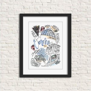 May include: A framed art print featuring a hand-drawn map of Omaha, Nebraska. The artwork includes illustrations of local landmarks such as the Joslyn Art Museum, Lauritzen Gardens, and the Durham Museum, with the city name in cursive.