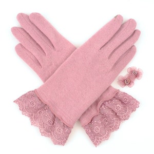 May include: A pair of light pink gloves with delicate lace cuffs, and two small pink flower accessories. The gloves are made of a soft material and are displayed on a white background.