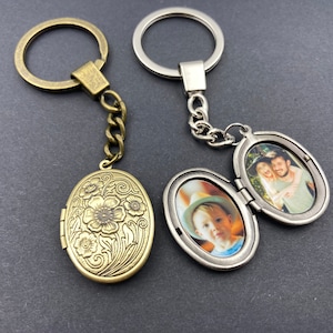 Puede incluir: Dos llaveros con medall&oacute;n de foto ovalado. Uno es plateado con una foto de un ni&ntilde;o peque&ntilde;o. El otro es de bronce con un dise&ntilde;o floral grabado.
