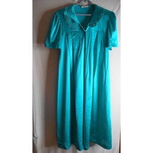 Könnte beinhalten: Ein blauer Satin-Morgenmantel mit einem weißen Spitzenkragen und kurzen Ärmeln.