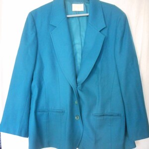 May include: A teal blazer with a single button closure and two pockets. The blazer has a notched collar and a plain front.