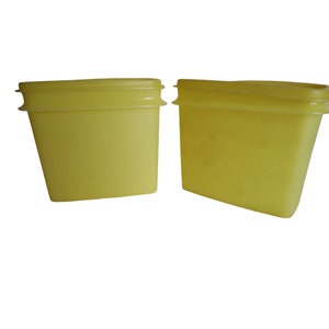 Puede incluir: Dos recipientes de plástico amarillo con tapas. Los recipientes son de forma rectangular y tienen un acabado liso y brillante.