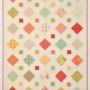 A quilt with a white background and a diamond pattern. The diamonds are in various colors, including red, pink, green, brown, and yellow. The quilt is edged with a red and white trim.