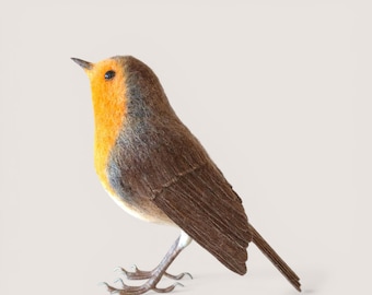 May include: A handcrafted decorative bird figurine. The bird features a vibrant orange breast, a gray and brown body, and a long, slender tail. Its legs are silver-colored, and it is posed looking upwards.
