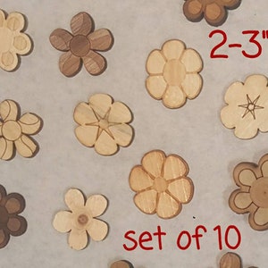 May include: Set of 10 wooden flower shapes, each measuring 2-3 inches in diameter. The flowers are in various shades of brown and have different designs.