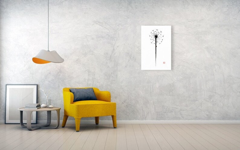 May include: A minimalist art print featuring a black dandelion silhouette against a white background. The artwork is displayed on a wall in a modern living room setting, alongside a yellow armchair and a side table.
