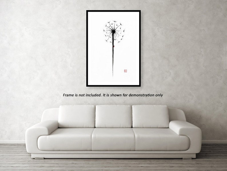 May include: Black framed art print featuring a minimalist dandelion design. The artwork is in black ink on a white background, with a long stem and a small red square in the corner. The text "Frame is not included. It is shown for demonstration only" is below the frame.