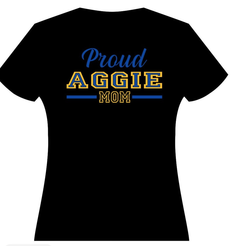May include: Black t-shirt with the text "Proud Aggie Mom" in blue and gold lettering.