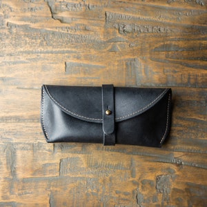 Black full grain leather sunglasses case. Keep your shades safe in this hand made sunglasses case that can be personalized with your initials. There is a brass knob to latch the case shut and keep your eyewear safe.