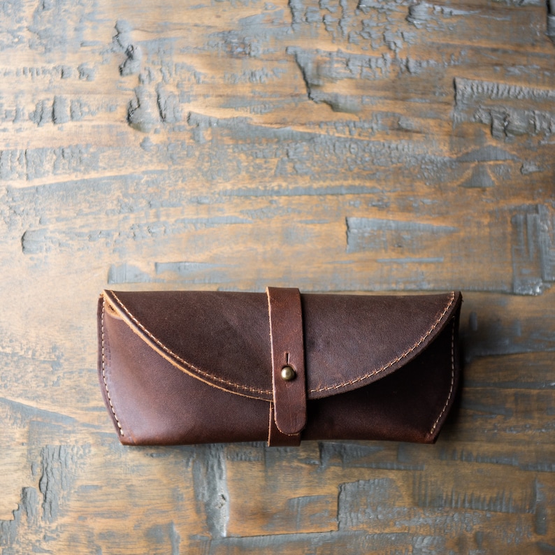 Brown full grain leather sunglasses case. Keep your shades safe in this hand made sunglasses case that can be personalized with your initials. There is a brass knob to latch the case shut and keep your eyewear safe.