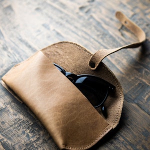 Tan full grain leather sunglasses case. Keep your shades safe in this hand made sunglasses case that can be personalized with your initials. There is a brass knob to latch the case shut and keep your eyewear safe.