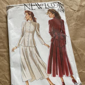 May include: Vintage New Look sewing pattern 6199. The pattern features illustrations of two women's outfits: a cream-coloured suit with a peplum jacket and a burgundy dress with a bow detail. The pattern envelope is off-white.