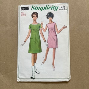 Może przedstawiać: Wzór szycia Simplicity numer 6306 na sukienkę. Wzór jest dla rozmiaru 14, biust 86 cm. Wzór pokazuje dwie modelki w sukience, jedna w zielonej, a druga w różowej.