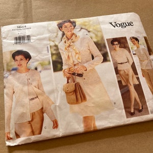 Puede incluir: Patrón de costura Vogue número 1664 para las tallas 8-10-12. El patrón presenta tres estilos diferentes para un cárdigan, una falda y una blusa. Las modelos llevan ropa beige y blanca.