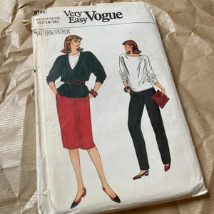 May include: A vintage Very Easy Vogue sewing pattern. The pattern features illustrations of two women's outfits: a black jacket with a red skirt and black pants with a white top. The pattern size is 12-14-16.