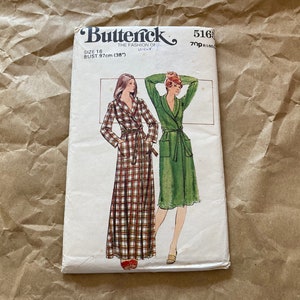 May include: A vintage sewing pattern for a long robe with a tie belt. The pattern is for size 16, with a bust measurement of 97 cm. The pattern shows two different styles of robes, one in a plaid fabric and one in a solid green fabric.