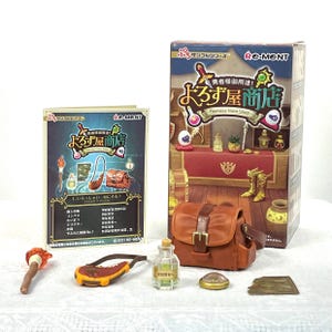 Pode incluir: Um conjunto de loja de itens de fantasia em miniatura com uma bolsa marrom, uma garrafa de poção e um livreto com texto japonês. O conjunto inclui uma caixa com as palavras "Fantasy Item Shop" e outros acessórios. Os itens estão dispostos em uma superfície branca.