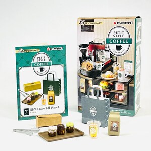 Pode incluir: Conjunto de brinquedos de café em miniatura com uma máquina de café, doces e xícaras de café. O conjunto inclui uma caixa de exibição, sacolas de papel e uma bandeja com sobremesas em miniatura. A embalagem apresenta o texto "PETIT STYLE COFFEE".