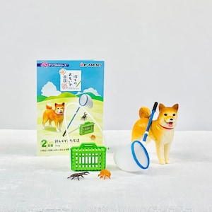 May include: A miniature plastic dog figurine with a blue and white net and a green cage. The dog is brown and white with a red collar. The figurine is part of a set of miniature toys for a dollhouse or playset.