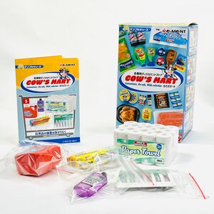 May include: Miniature grocery store items, including paper towels, packaged food, and cleaning supplies. The packaging features the text "COW'S MART" and Japanese text. Several items are in clear plastic bags.