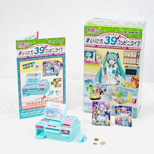 May include: A miniature light blue cash register toy with a pink calculator and a small display. The set includes miniature money, cards, and a box with the text "HATSUNE MIKU Convenience Store".