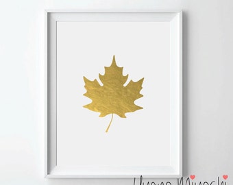 May include: A gold foil maple leaf print in a white frame. The print is on white paper.