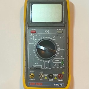 May include: A yellow and gray digital multimeter with a black display screen. The device has a rotary dial and multiple input jacks. The text "CONSTECH" and "P37772" are visible.