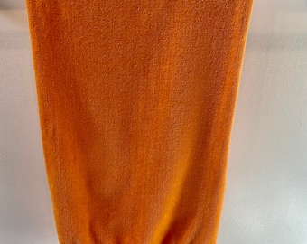 May include: A bright orange towel with a fringed edge hangs on a silver towel rack.